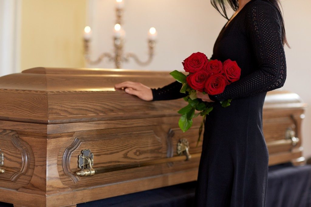 woman standing next to coffin