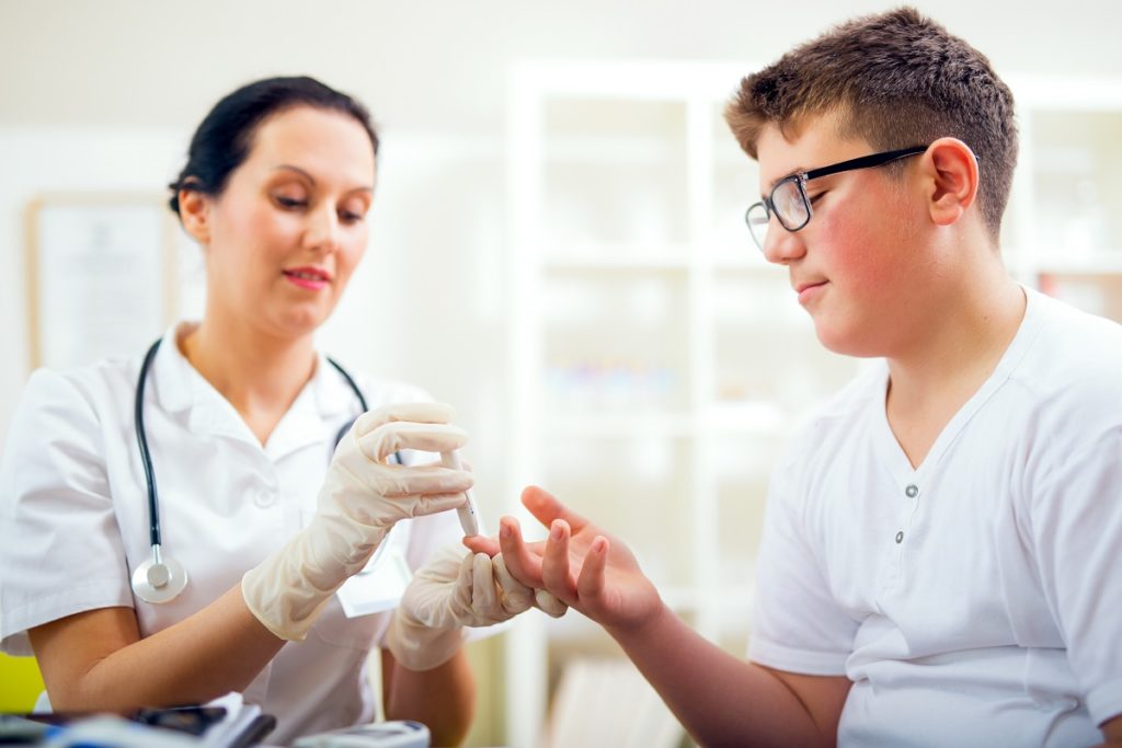 nurse checking blood sugar of a kid