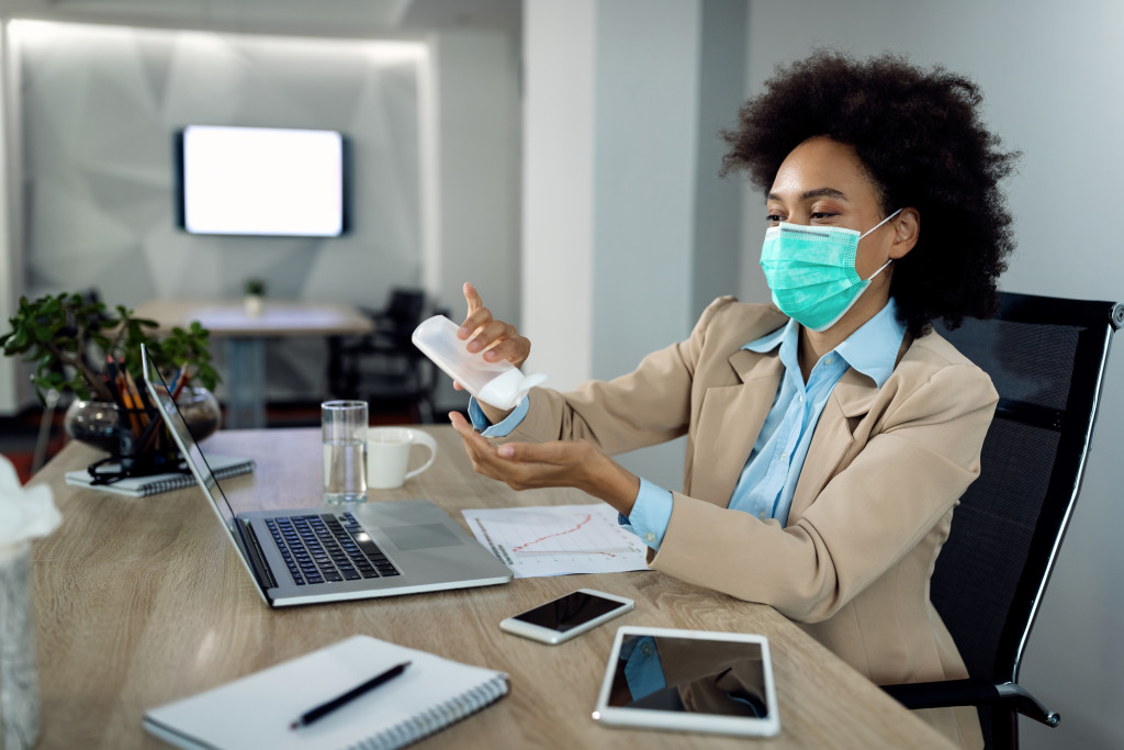 A business woman using hand sanitizer