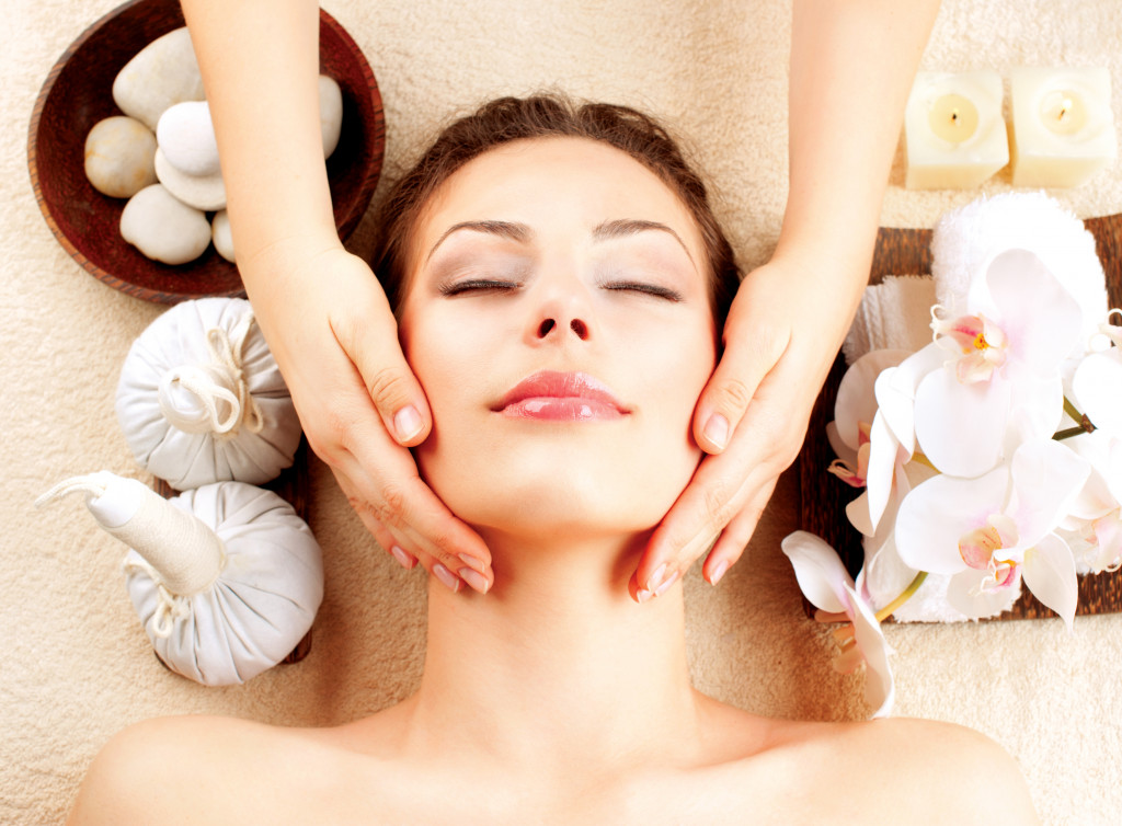 Hands giving a woman a facial massage